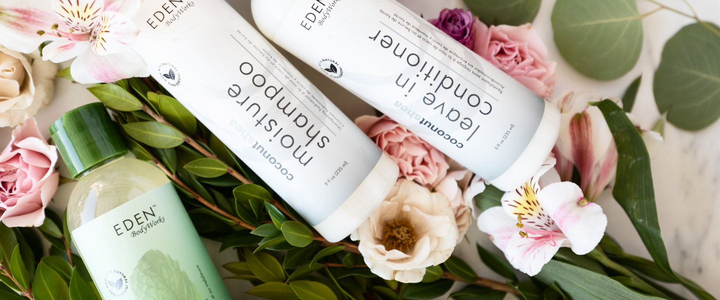 EDEN BodyWorks bottled products laying across cut flowers